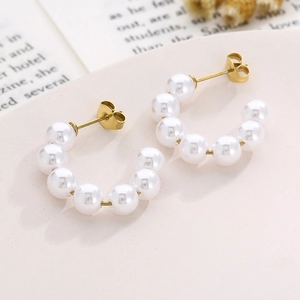 Elegant 18K gold plated C-shaped hoop earrings with white pearls on artistic background