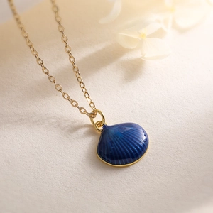 Close-up of 18K gold-plated necklace featuring a textured blue shell enamel pendant