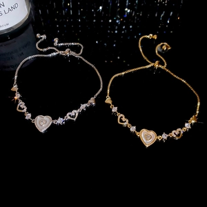 Detailed macro view of heart charm bracelets with zircon accents and adjustable slider