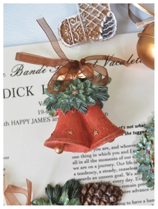 Close-up of red Christmas bells with holly leaves and stars on vintage paper background