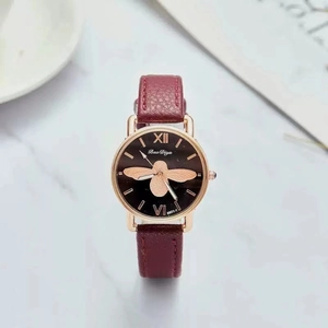 Detailed macro shot of a black dial featuring a golden bee motif and Roman numerals