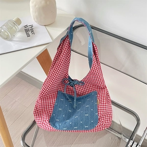 Detail of red gingham fabric tote with denim pocket and white bow print on acrylic chair