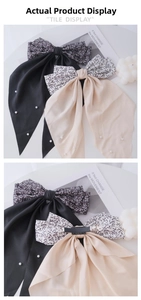Detail of floral bow hair clip with white pearls and long ribbons in black and champagne