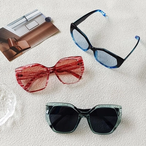 Detailed view of three stylish polygon sunglasses in blue, red, and green frames