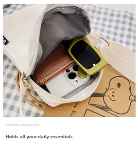 Detail view of white canvas crossbody bag showing spacious interior with zipper closure