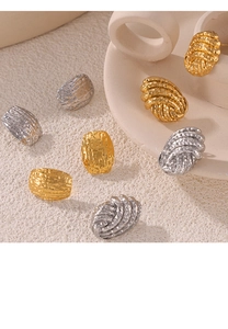 Détail artistique de boucles d'oreilles dorées et argentées martelées sur un plateau