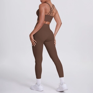 Dettaglio del set yoga marrone scuro con reggiseno sportivo incrociato e leggings a vita alta
