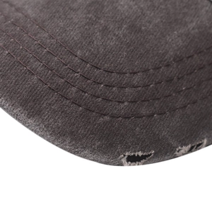 Macro view of distressed denim baseball cap brim with vintage frayed edges and stitching