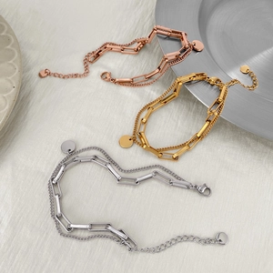 Detailed view of layered titanium steel bracelets in rose gold, gold, and silver finishes