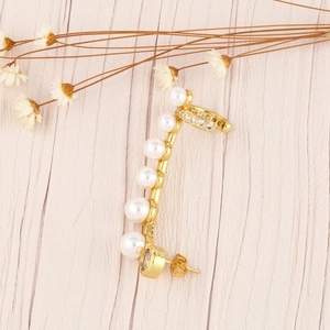 Κομψό χρυσό σκουλαρίκι ear cuff με 6 πέρλες και ζιργκόν σε ξύλινο φόντο