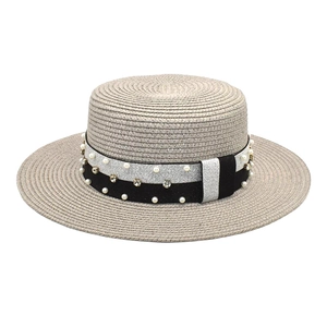 Detail of wide brim straw hat featuring pearl and rhinestone studded silver trim
