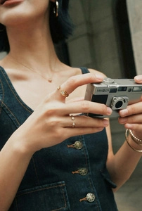 Detail view of gold star open ring and minimalist zircon jewelry set on a model