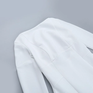 Detailed close-up of white long-sleeve dress neckline with textured woven fabric