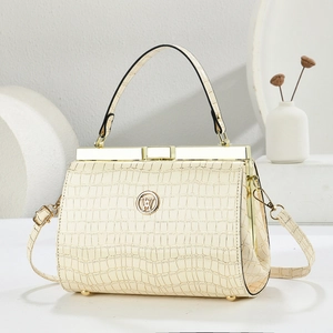 Close-up of premium cream faux crocodile skin texture and elegant gold clasp on evening bag