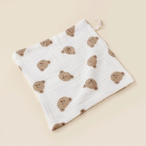 Detail von weißem Baby-Mulltuch aus Baumwolle mit Bärenprint und praktischer Schlaufe