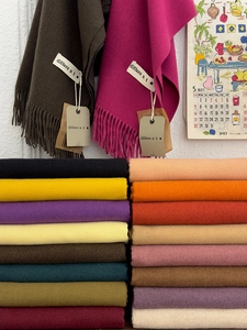 Detailed view of colorful cashmere feel scarves with tassel edges and soft knit texture
