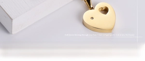 Detailaufnahme der goldenen Herz-Halskette mit einem kleinen funkelnden Zirkonia-Stein