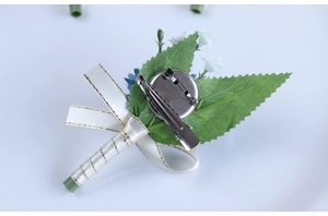 Detail of wedding boutonniere back showing secure silver metal clip and safety pin attachment