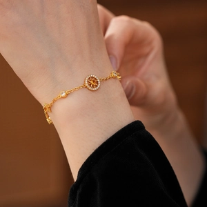 Close-up of gold eight-pointed star compass pendant bracelet with zircon on wrist