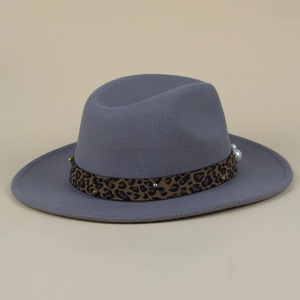 Détail du ruban léopard avec clous dorés et perles sur un chapeau en laine grise