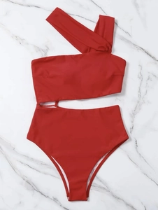 Detail of red one-shoulder monokini featuring side cutout and smooth elastic swimwear fabric