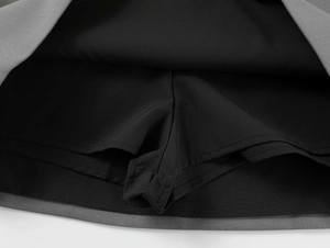 Detailed view of the anti-exposure black safety shorts under the grey A-line skirt