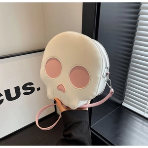 Close-up of a white skull-shaped crossbody bag with pink heart-shaped nose detail