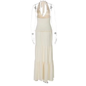 Detail view of the open back and layered tiered skirt of the beige halter neck maxi dress