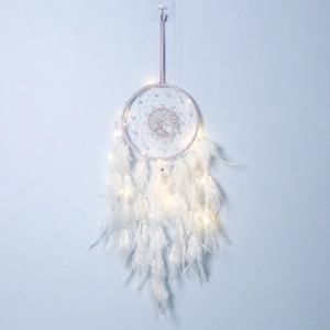 Detail of pink Tree of Life dreamcatcher with glowing LED lights and soft white feathers