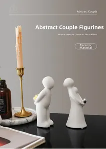 Detail of matte white ceramic couple sculptures with heart and flower accents in home decor