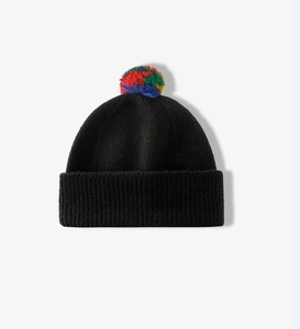 Close-up of a black knitted beanie featuring a vibrant multi-colored faux fur pompom