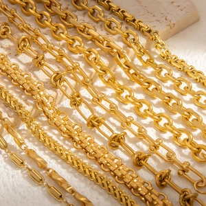 Detail view of assorted 18k gold plated titanium steel chain link bracelets on stone
