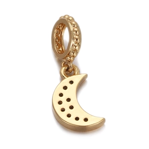 Macro detail of a gold-plated moon pendant with small hole accents on a white background