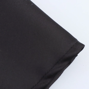 Detailed macro view of black satin fabric with professional double-stitched hem finish