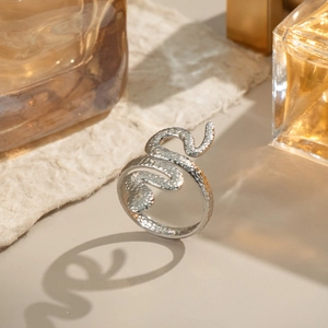 Bague serpent argentée minimaliste avec texture d'écailles sur fond clair élégant