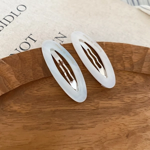 Close-up of marble pattern acetate oval hair clips with Barrette La France engraving