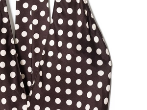 Détail du tissu marron à pois de la robe montrant la texture lisse et le col licou