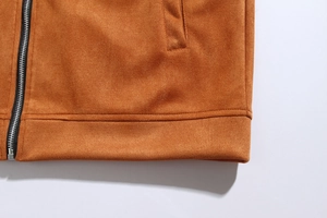 Detail of brown suede jacket showing high-quality metal zipper and stitching craftsmanship