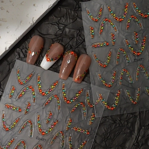Close-up of French crescent smile nail stickers with colorful rhinestones on model nails