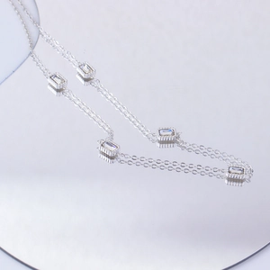 Detail of silver double-layered chain necklace with rectangular clear zircon stones