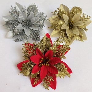 Close-up of artificial glitter poinsettia flowers in gold, silver, and red for Christmas