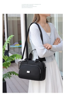 Detail of water-resistant black nylon tote bag with silver metal plaque on exterior