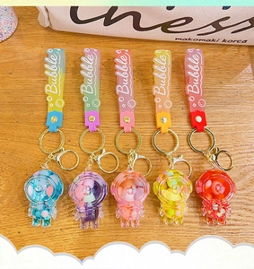 Close-up of colorful astronaut liquid quicksand keychains on a rustic wooden surface