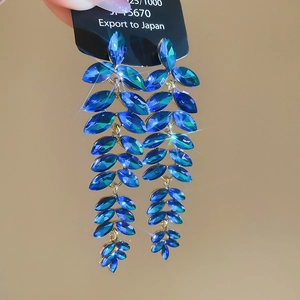 Macro shot of blue crystal water drop tassel earrings with sparkling leaf design details