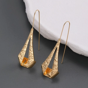 Detail of gold geometric triangle earrings with a unique hammered texture and hook design
