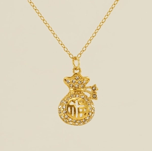 Dettaglio della collana con ciondolo a sacchetto portafortuna in oro 18k e strass