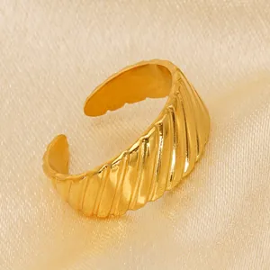 Minimalist golden ribbed open ring with a polished finish on a luxury silk background