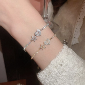 Close-up of sparkling gold and silver heart and star bracelets with white zircon inlay