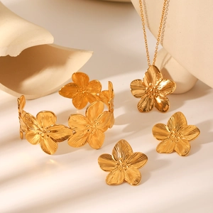 Golden 18K flower jewelry set with textured necklace, earrings and bracelet