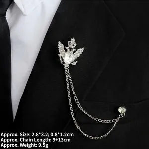 Detailed close-up of eagle crown brooch with rhinestone and chains on black blazer